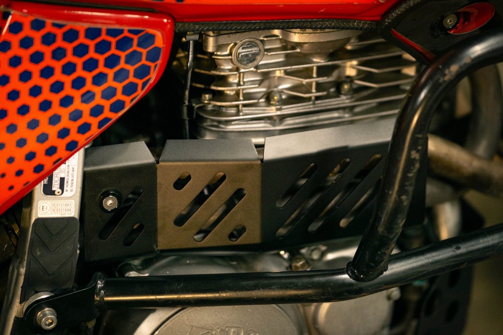 Protection de collecteur d'échappement ajourée montée sous le cylindre d'une Honda NX650 Dominator RD08